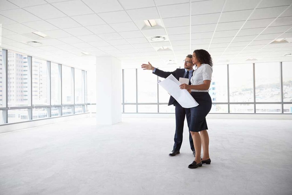 A real estate agent discusses home features with a couple in a comfortable, furnished living room.