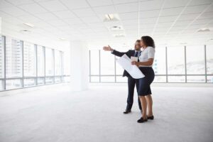 A real estate agent discusses home features with a couple in a comfortable, furnished living room.